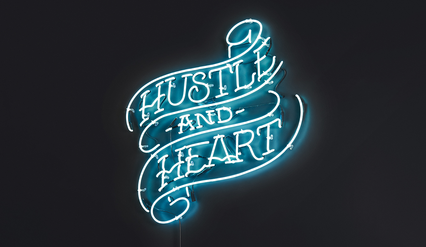 Neon sign at Bulletproof office that says 'Hustle and Heart'