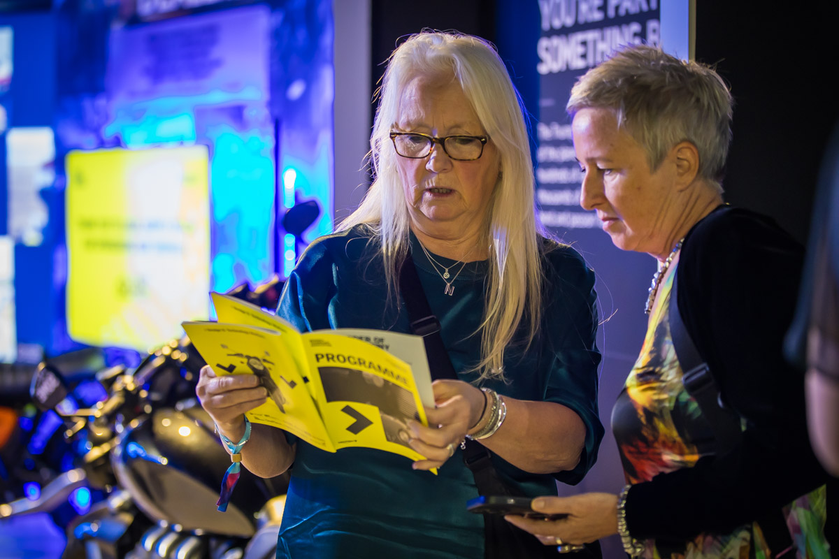 Two people reading the programme