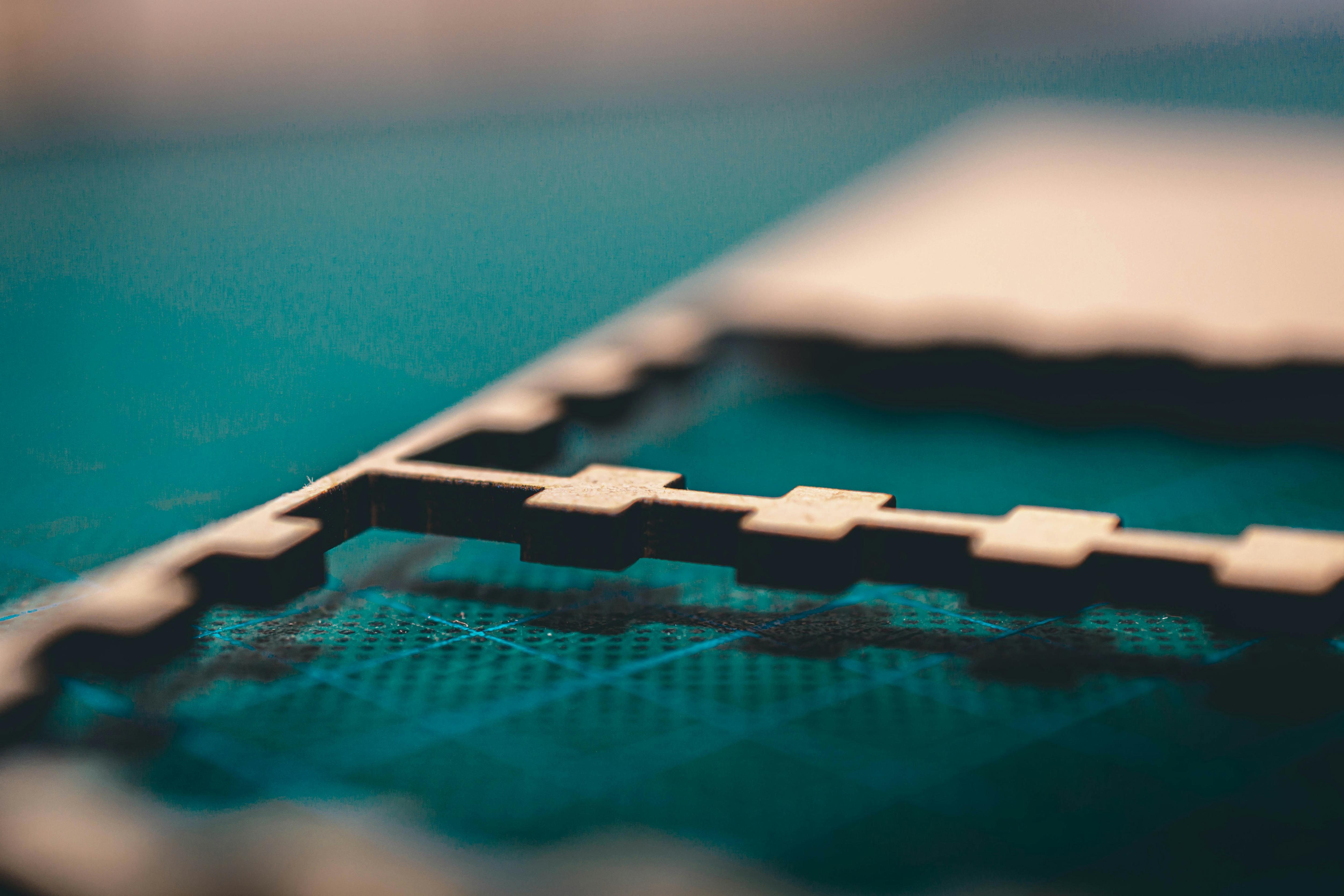 Close-up of a laser-cut or CNC-cut sheet material on a cutting bed, showing precise interlocking shapes.