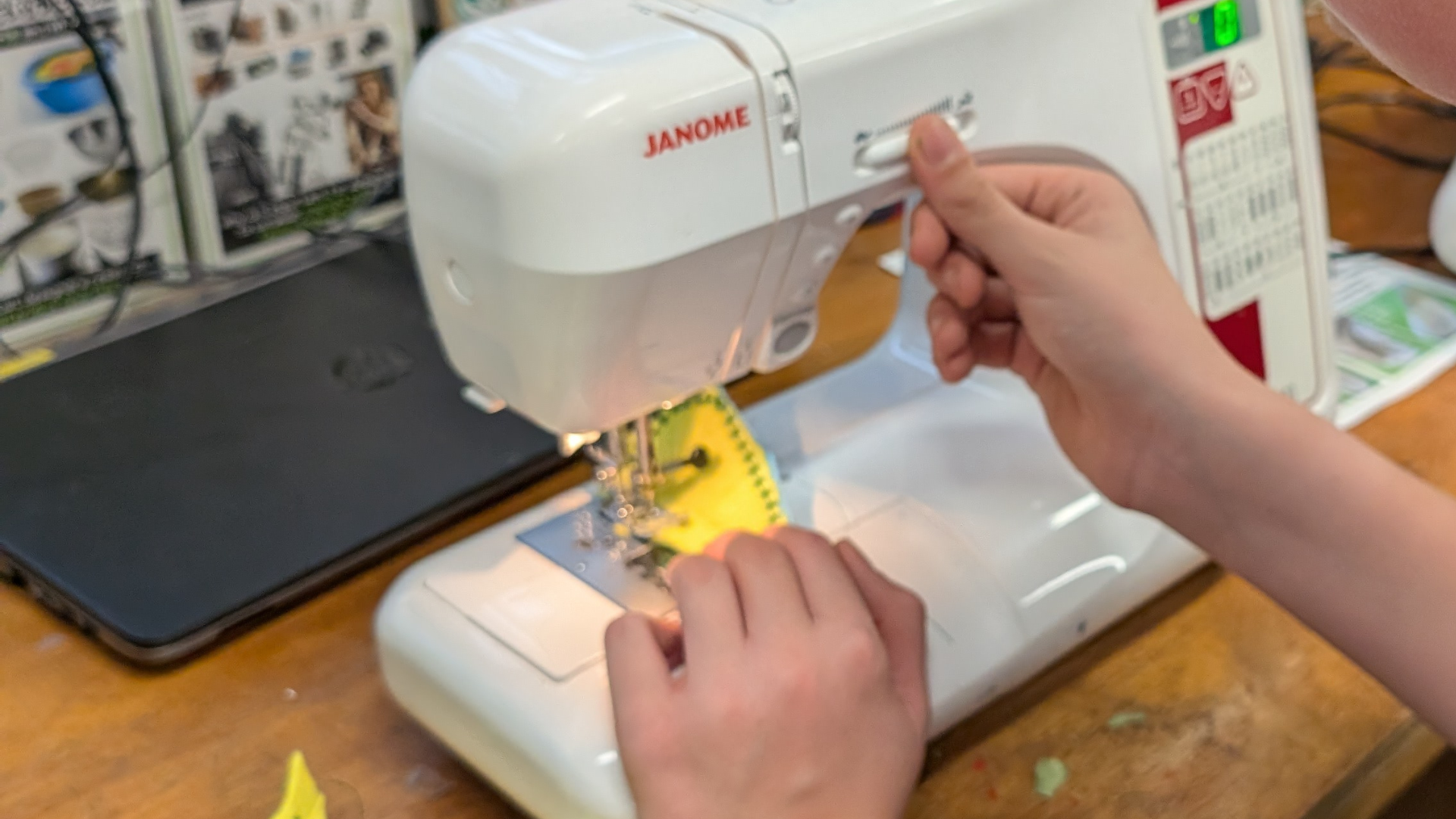 Student using a sewing machine to stitch fabric, practising textile construction skills in a design and technology lesson.
