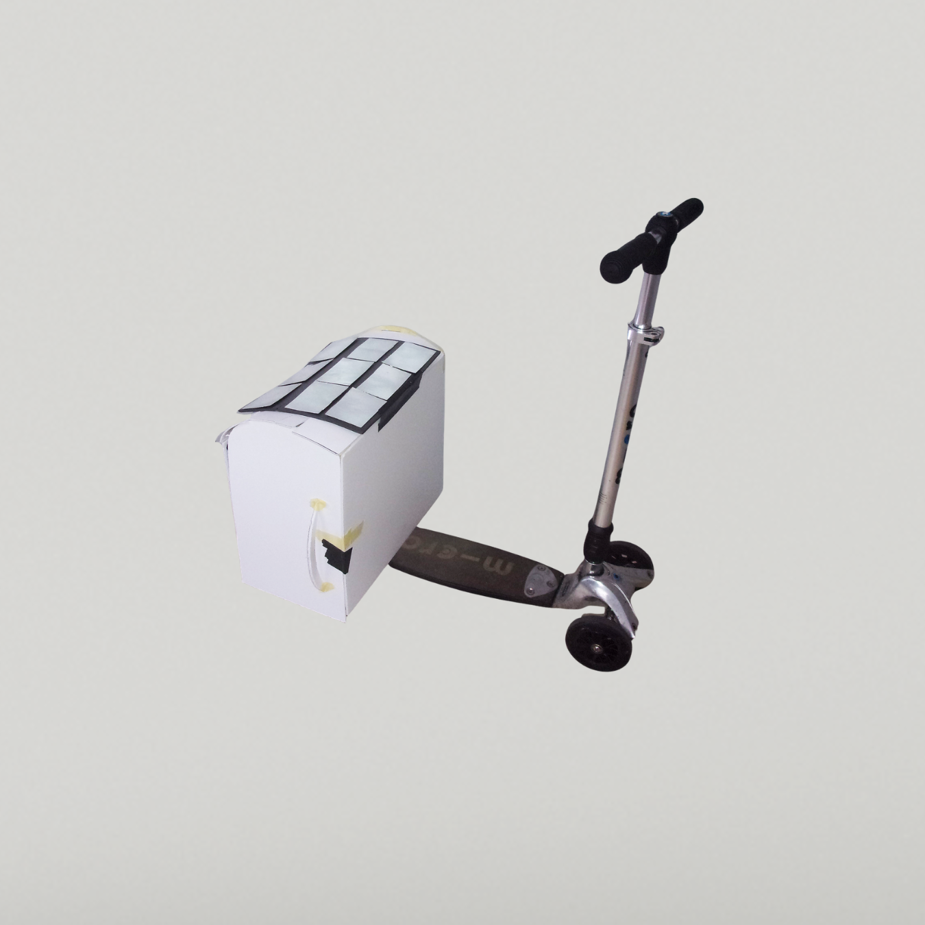 Student-made card prototype attached to a scooter, featuring a box-shaped cargo carrier with a solar panel design on top