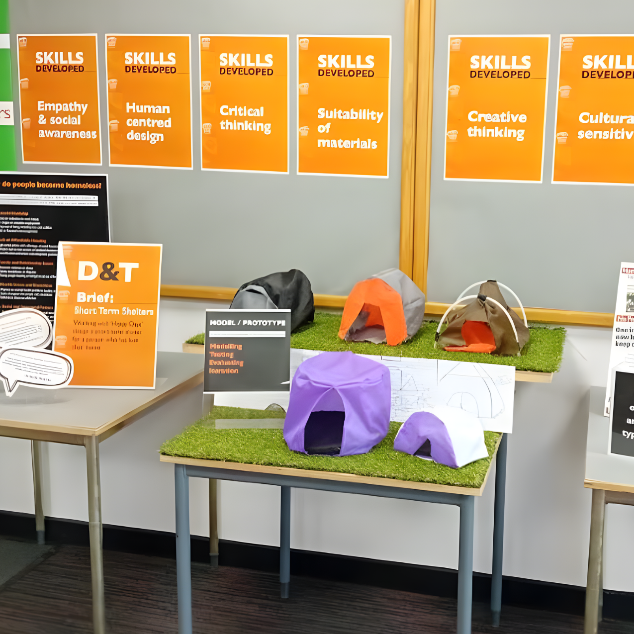 Display of student-designed shelter prototypes made from fabric and lightweight structures, presented on grass bases with supporting D&T project boards and skills posters