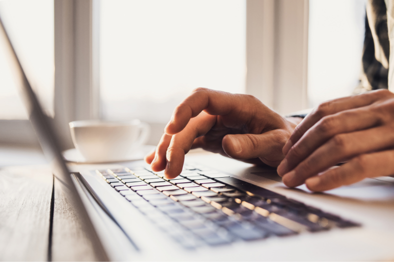 Close up of hands typing on a laptop