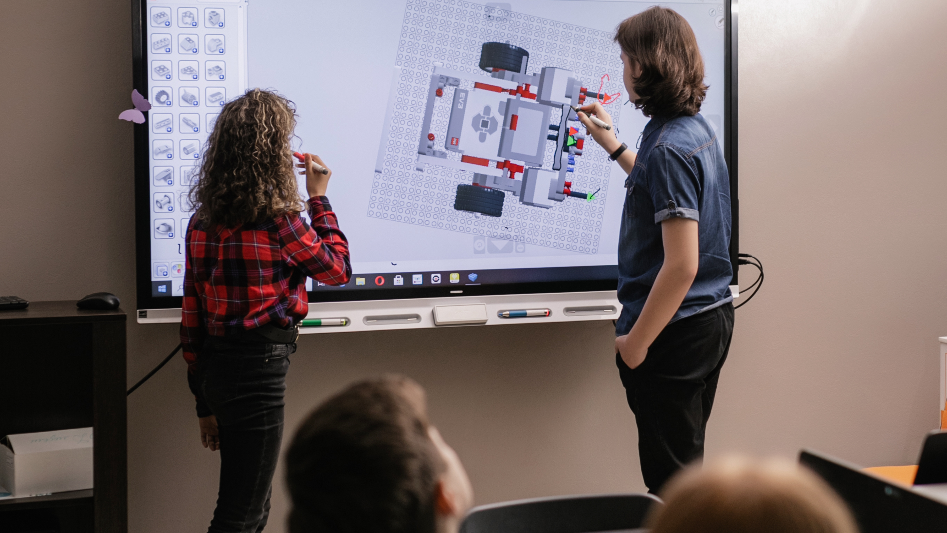 Two students working on a digital blackboard.