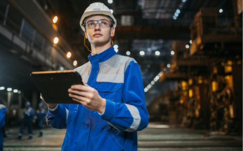 The image shows a person wearing a blue uniform and holding a tablet.